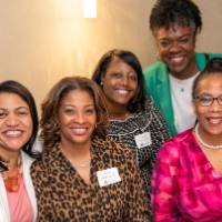 5 women at a table smiling